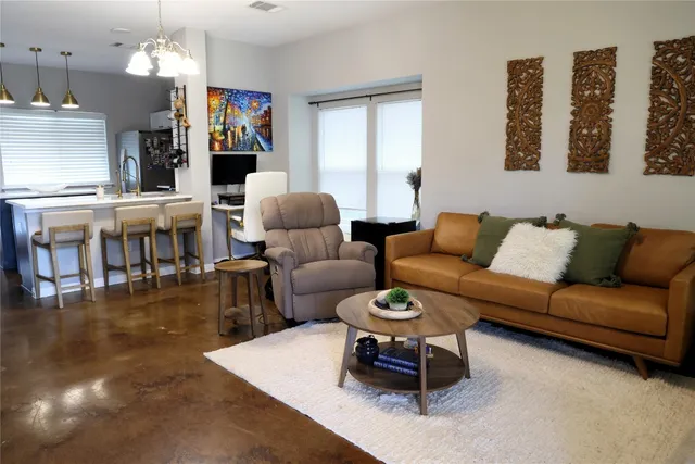 a living room with furniture a rug and a chandelier