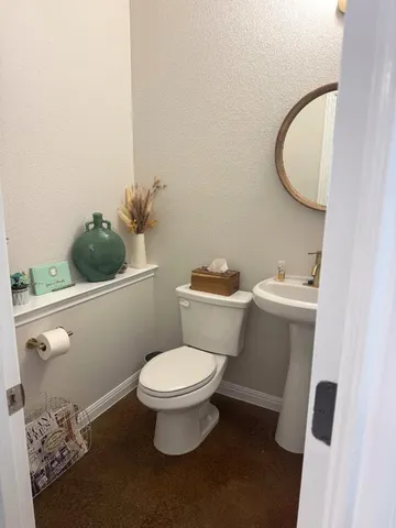 a white toilet sitting next to a bathroom sink and vanity