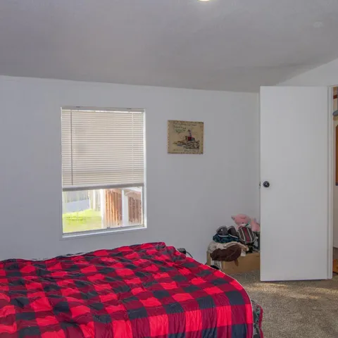 a bedroom with a bed and a window