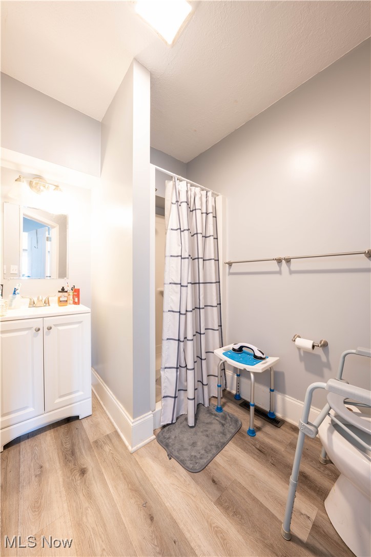 1709 Elm Road Northeast Warren, OH 44483 - Photo 9 of 21 Bathroom featuring wood-type flooring, a shower with curtain, vanity, and toilet