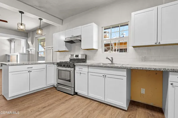 a kitchen with granite countertop white cabinets and white appliances