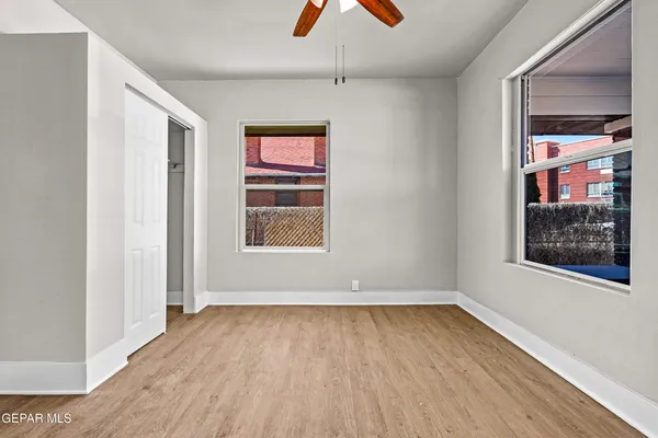 an empty room with wooden floor and windows