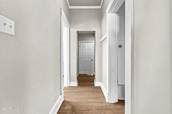 a view of a hallway with a room and wooden floor