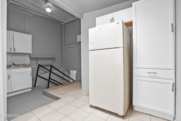 a white refrigerator freezer and a stove sitting inside of a kitchen
