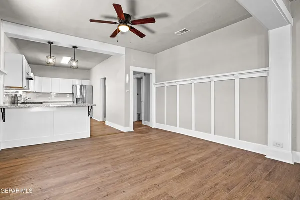 a view of kitchen with stainless steel appliances wooden floor and window