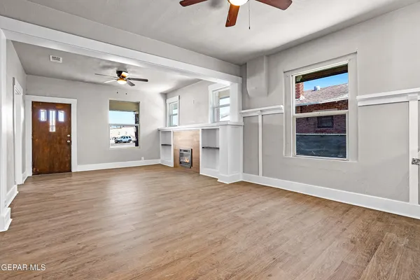 a view of an empty room with a window and fireplace