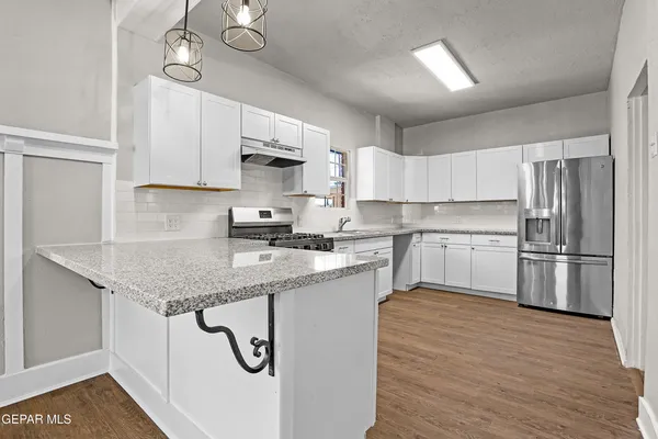 a kitchen with stainless steel appliances granite countertop a sink refrigerator stove and microwave