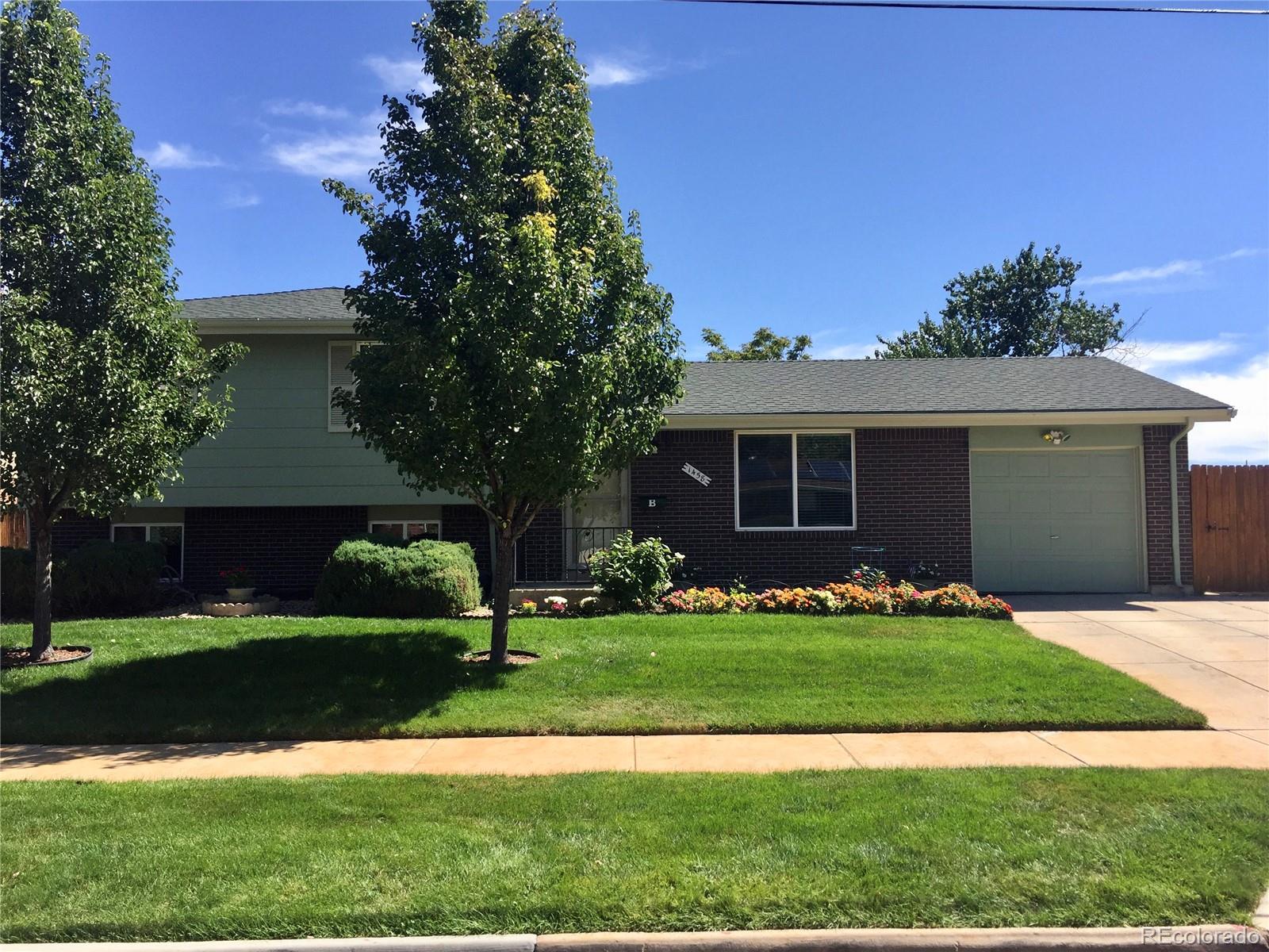 1458 South Oneida Street Denver, CO 80224 - Photo 1 of 33 a front view of a house with a garden