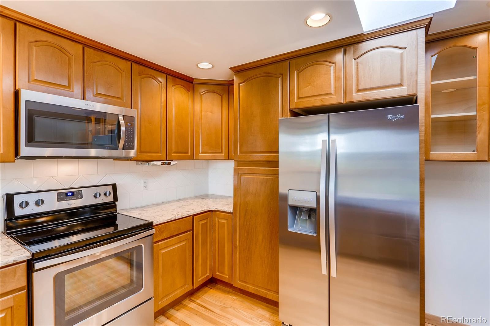 1458 South Oneida Street Denver, CO 80224 - Photo 11 of 33 a kitchen with stainless steel appliances granite countertop a refrigerator and a stove top oven