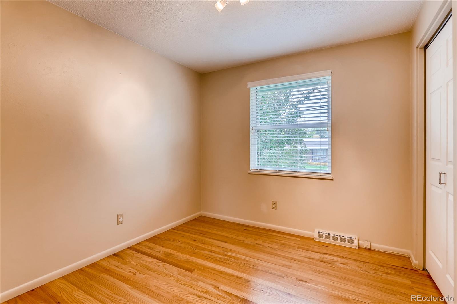 1458 South Oneida Street Denver, CO 80224 - Photo 17 of 33 a view of an empty room with wooden floor and a window