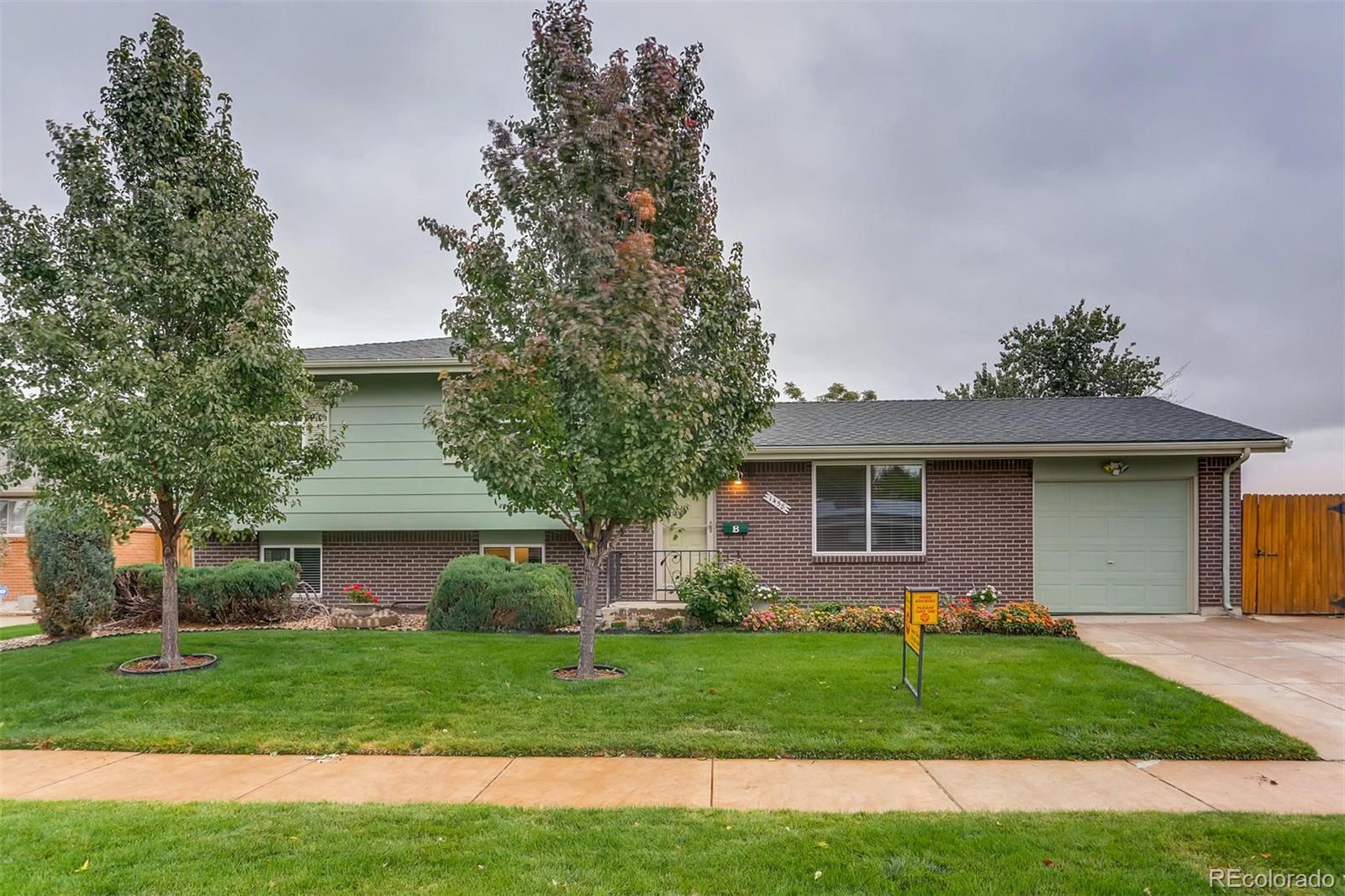 1458 South Oneida Street Denver, CO 80224 - Photo 2 of 33 a front view of a house with a garden and yard
