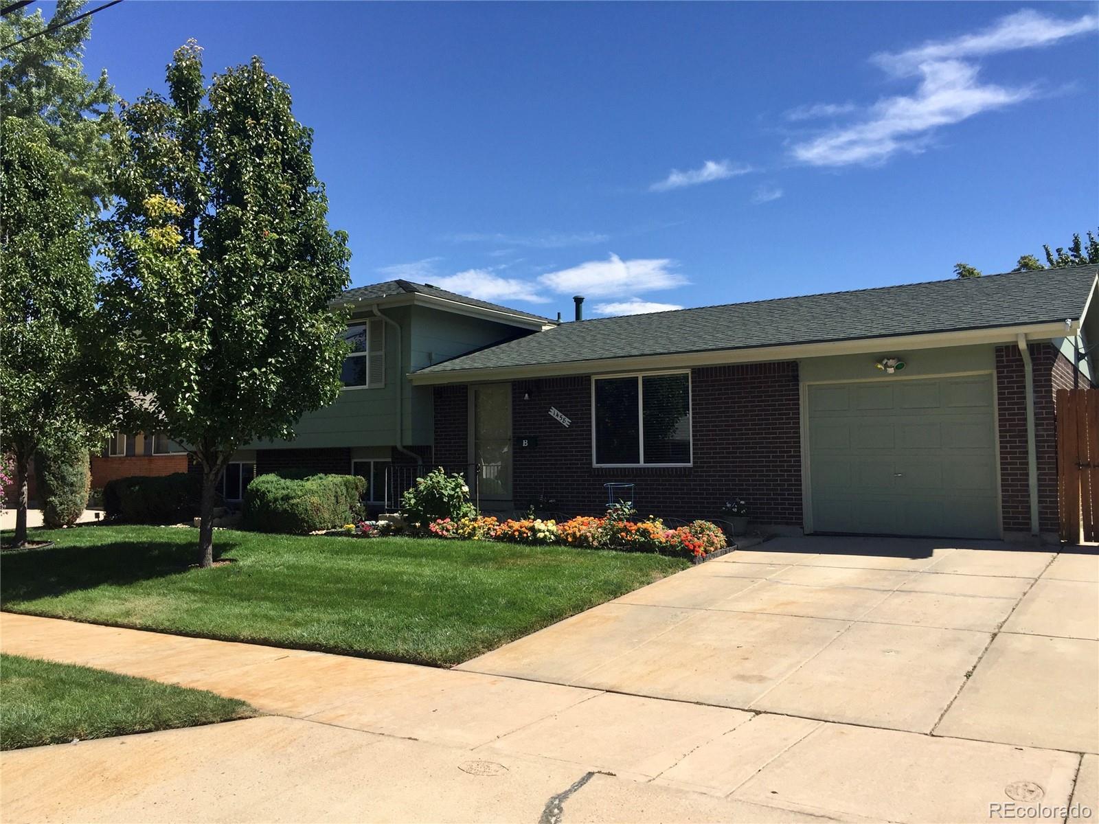 1458 South Oneida Street Denver, CO 80224 - Photo 3 of 33 a front view of a house with a yard and trees