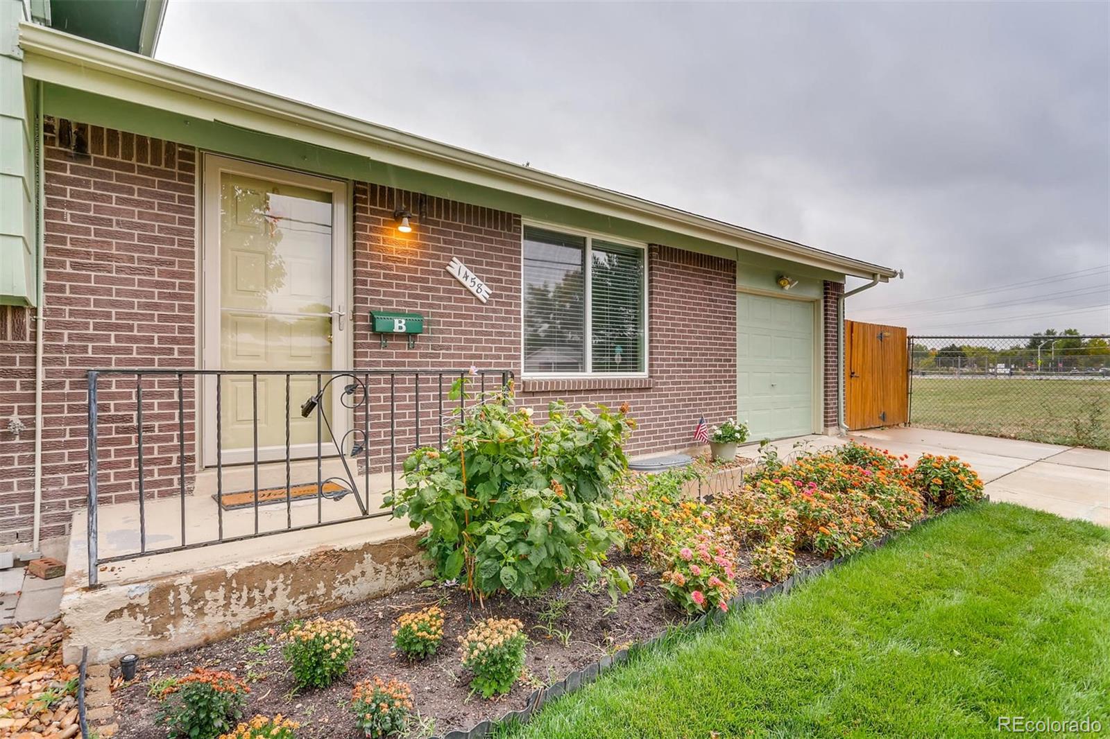 1458 South Oneida Street Denver, CO 80224 - Photo 4 of 33 a front view of a house with garden