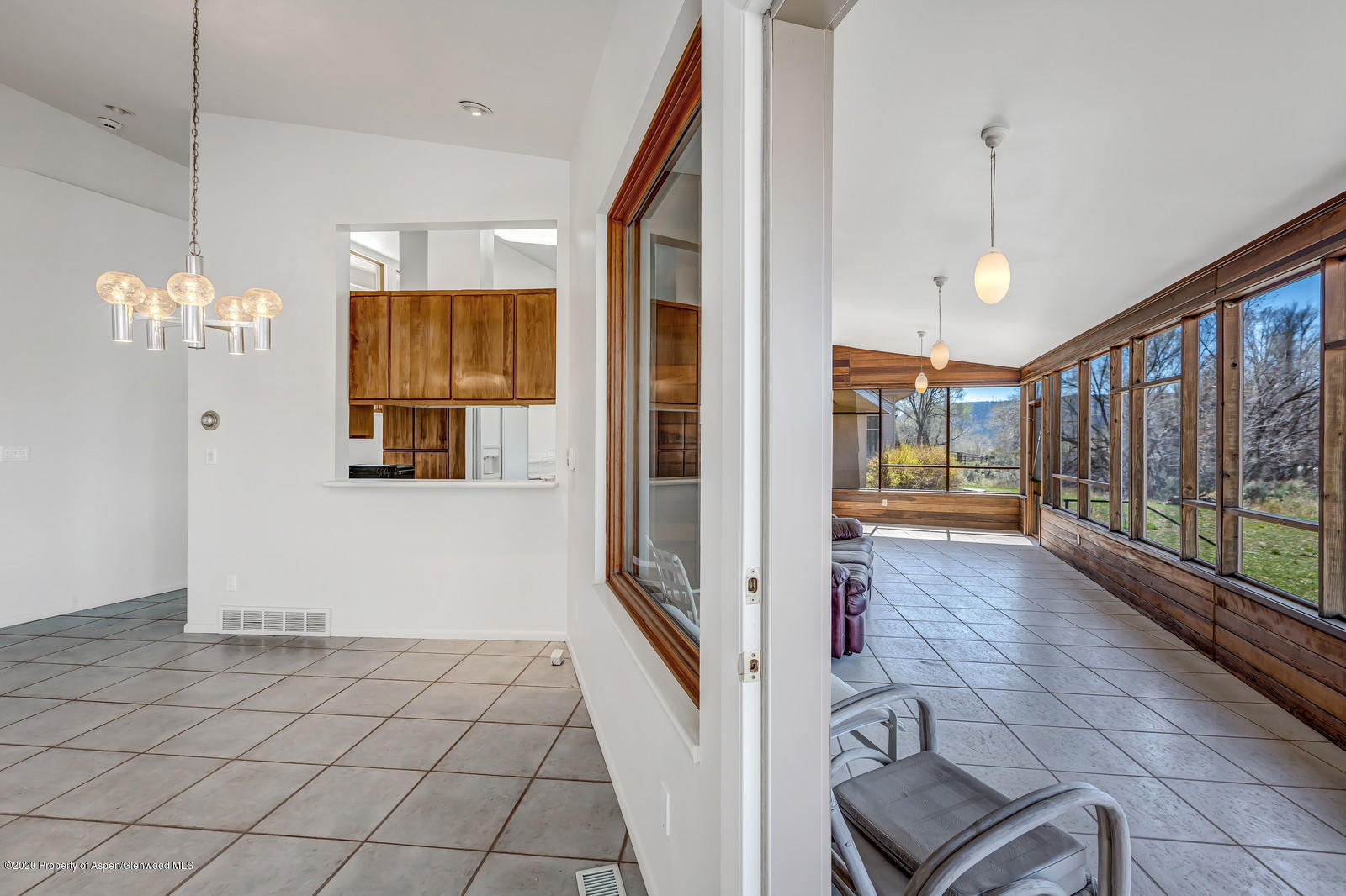735 Ute Avenue Rifle, CO 81650 - Photo 10 of 30 a view of a hallway with wooden floor and chandelier
