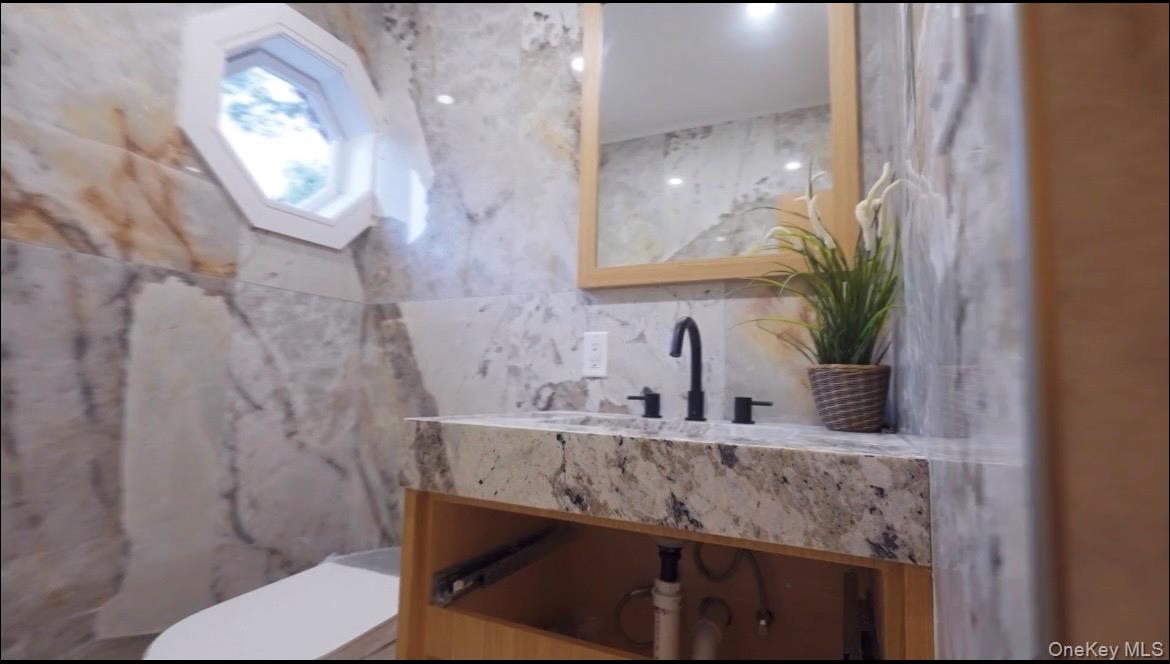 21 Wesleyan Road Commack, NY 11725 - Photo 8 of 9 a bathroom with a granite countertop sink a toilet and mirror