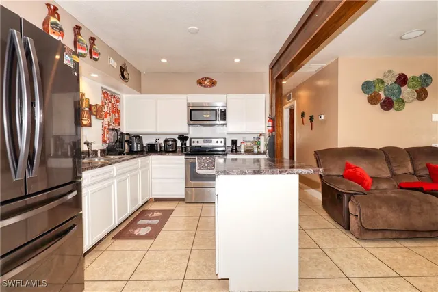 a kitchen with stainless steel appliances granite countertop a refrigerator and a stove top oven