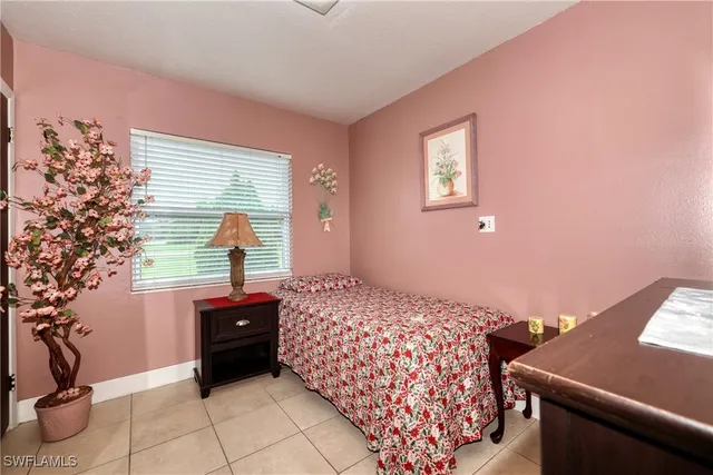 a bedroom with a bed and a potted plant