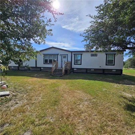 a view of a house with a backyard and a tree