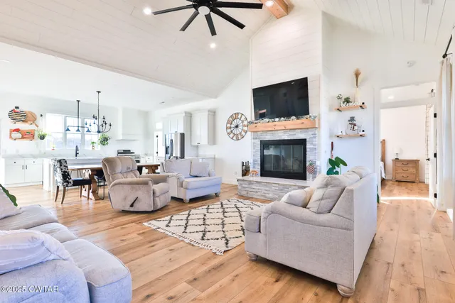 a living room with furniture a flat screen tv and a fireplace