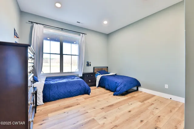 a bedroom with two beds and a large window