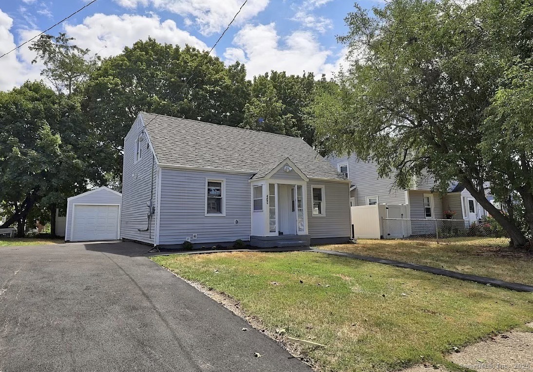 a view of a house with a yard and large tree