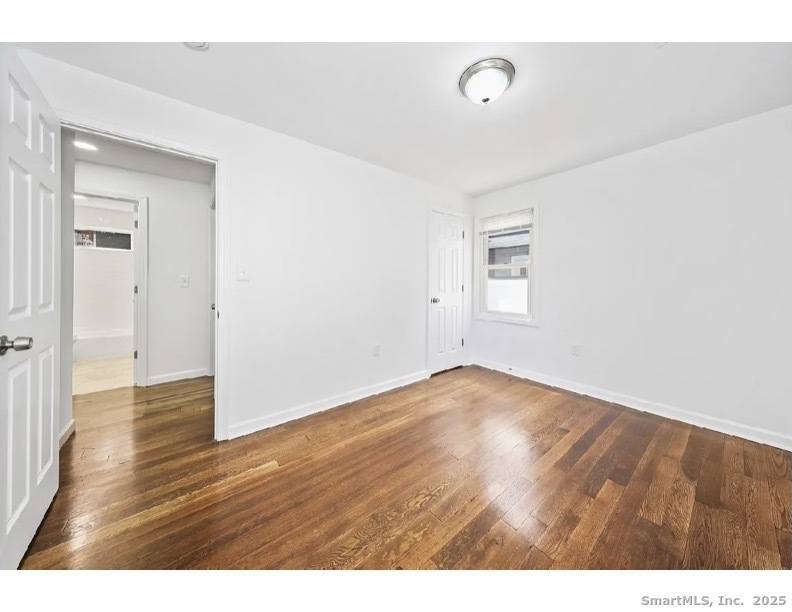 405 Ruth Street Bridgeport, CT 06606 - Photo 12 of 17 a view of an empty room with wooden floor and a window
