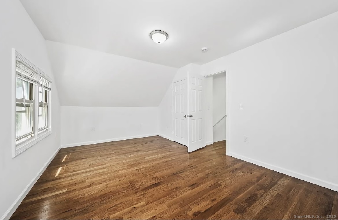 405 Ruth Street Bridgeport, CT 06606 - Photo 13 of 17 a view of an empty room with wooden floor and a window