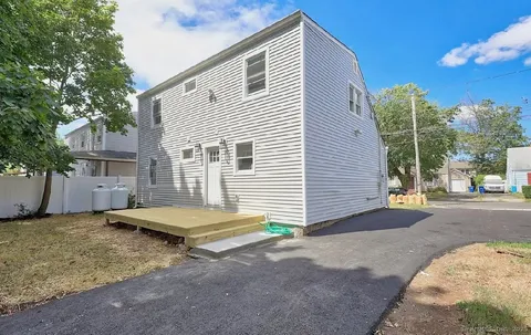 a view of a house with backyard and a tree