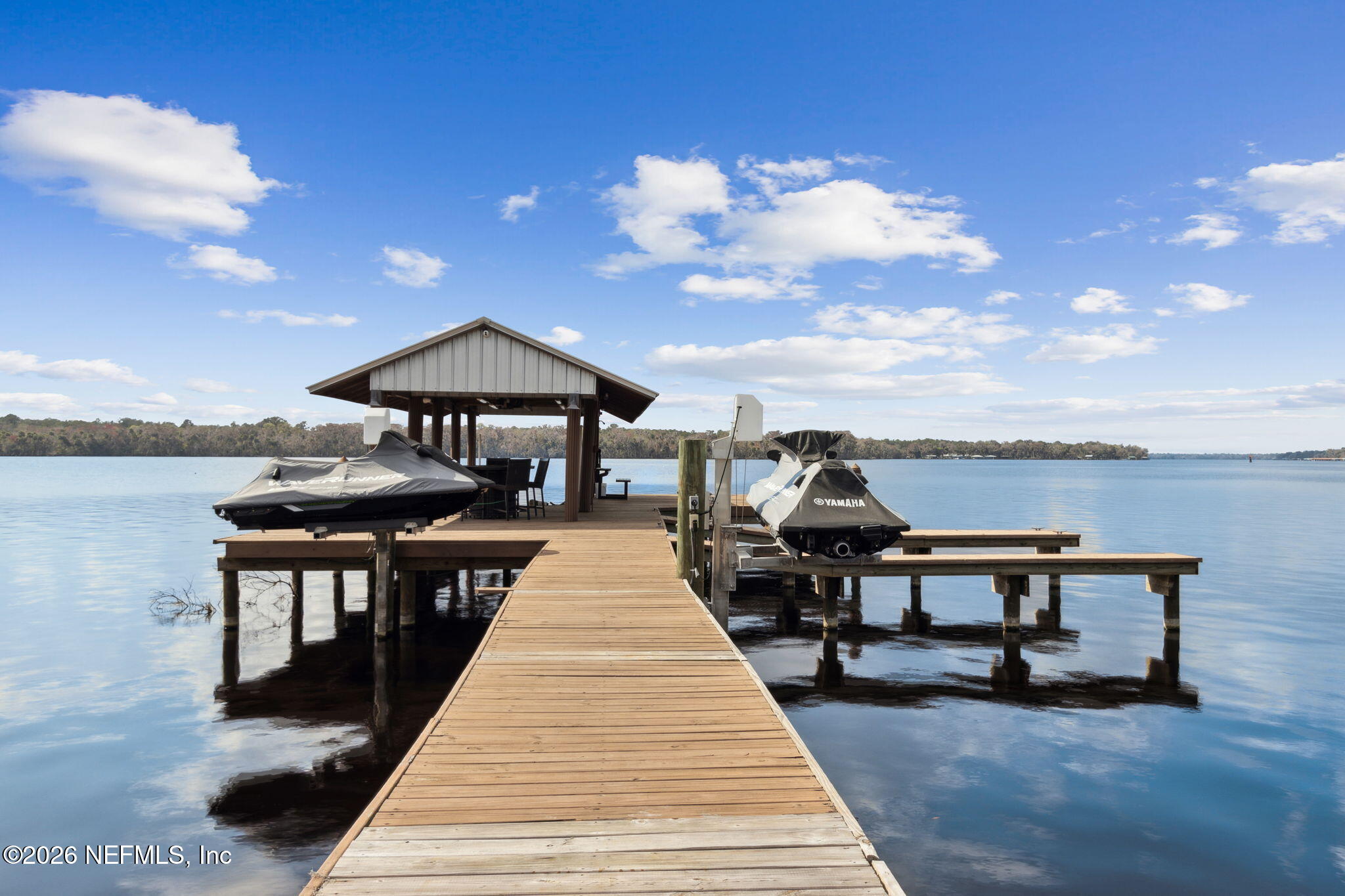 208 Lake George Point Drive Georgetown, FL 32139 - Photo 54 of 76 a roof deck with table and chairs under an umbrella with wooden floor