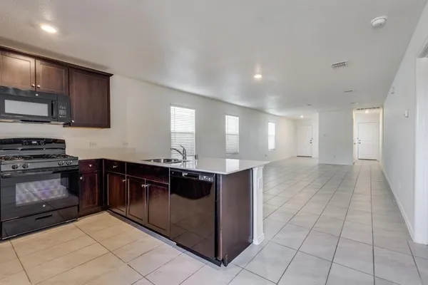 a kitchen with stainless steel appliances granite countertop a stove a sink and a microwave
