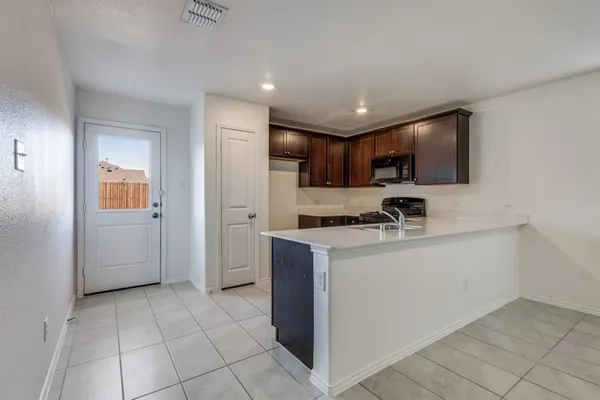 a kitchen with stainless steel appliances granite countertop a refrigerator and a stove top oven