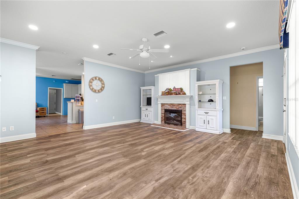 6551 Southeast 11th Loop Ocala, FL 34472 - Photo 16 of 46 an empty room with furniture and a fireplace