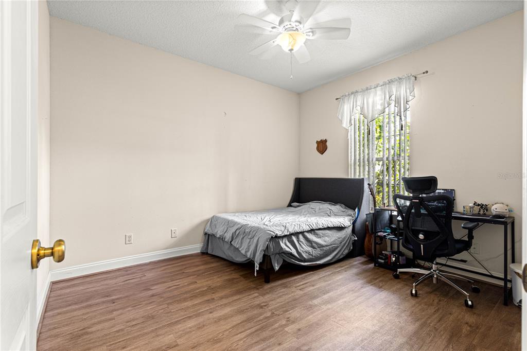 6551 Southeast 11th Loop Ocala, FL 34472 - Photo 27 of 46 a bedroom with a bed and a chandelier