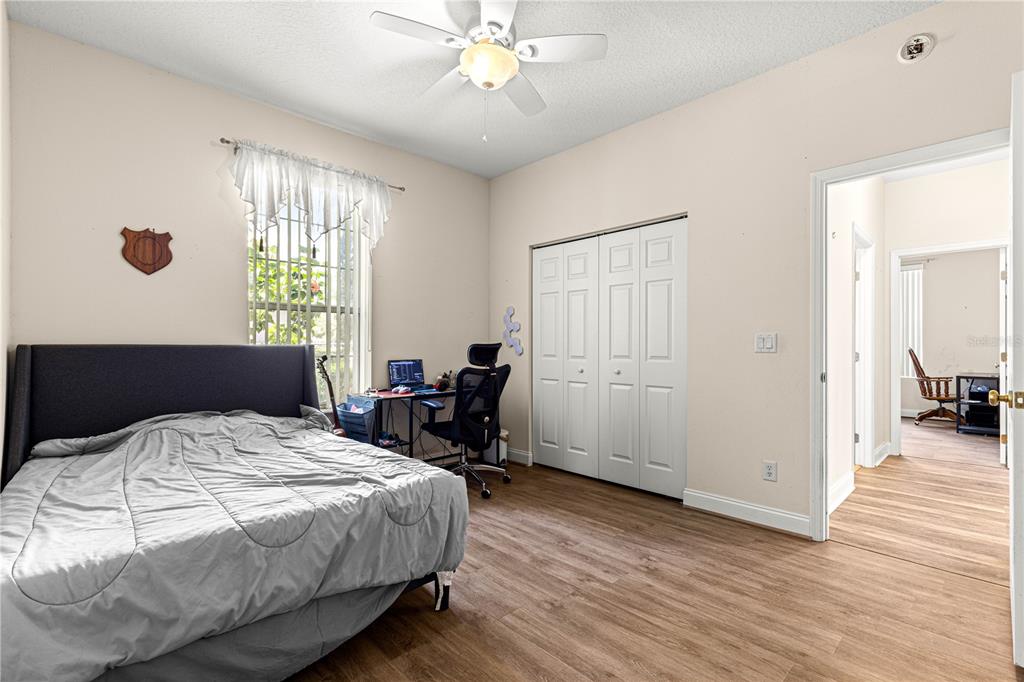 6551 Southeast 11th Loop Ocala, FL 34472 - Photo 28 of 46 a bedroom with a bed a dresser and wooden floor