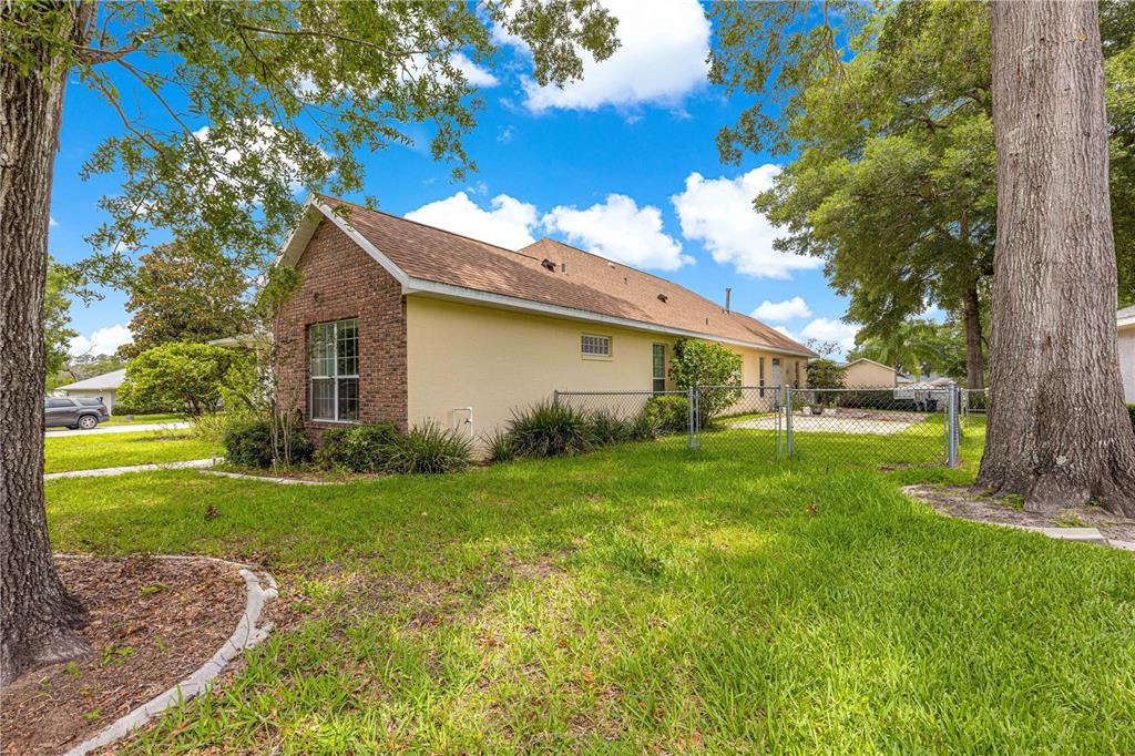 6551 Southeast 11th Loop Ocala, FL 34472 - Photo 37 of 46 a yellow house sitting in middle of the grass and covered with trees