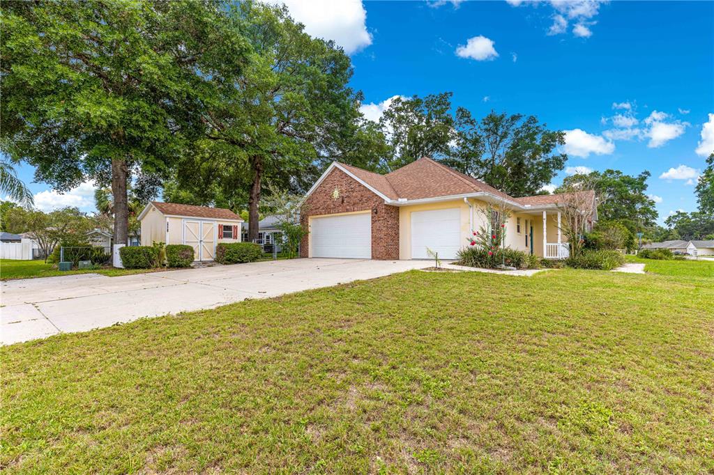 6551 Southeast 11th Loop Ocala, FL 34472 - Photo 43 of 46 a white house with a big yard plants and large trees
