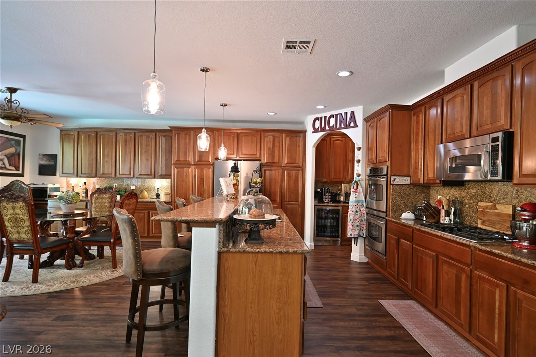 2729 Kildrummie Street Henderson, NV 89044 - Photo 9 of 42 A well-appointed kitchen showcasing a spacious island with bar seating and rich cabinetry.