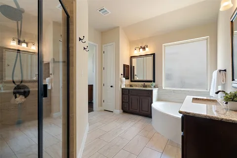 a bathroom with a double vanity sink a mirror a bathtub and shower