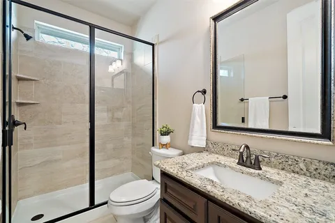 a bathroom with a granite countertop sink toilet and shower