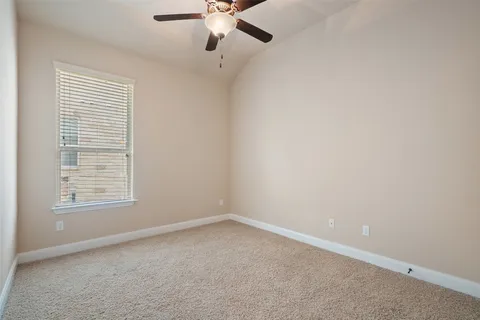 an empty room with a window and a fan