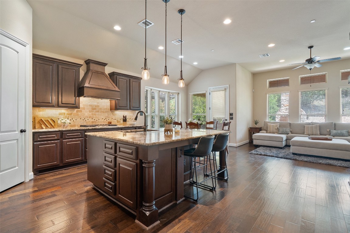 209 Maxwell Way Austin, TX 78738 - Photo 3 of 32 a spacious kitchen with stainless steel appliances granite countertop a sink a stove and a wooden floors