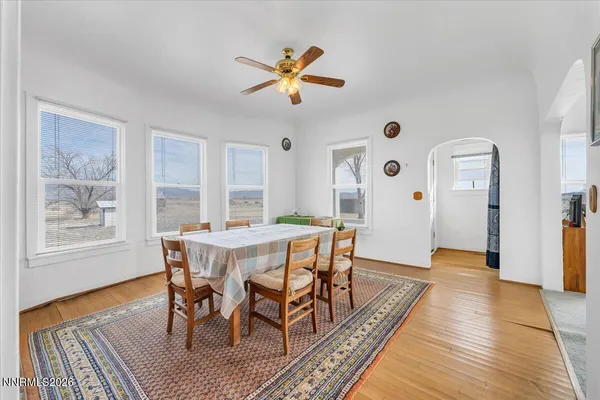 a dining room with wooden floor a chandelier a wooden table and chairs