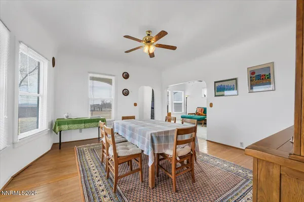 a dining room with wooden floor and a chandelier