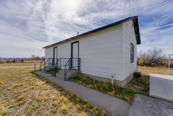 a backyard of a house with lawn chairs and iron fence