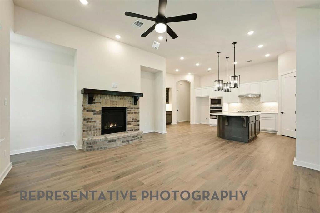 2620 Brooklyn Street Forney, TX 75126 - Photo 4 of 19 a living room with stainless steel appliances kitchen island a fireplace and a chandelier