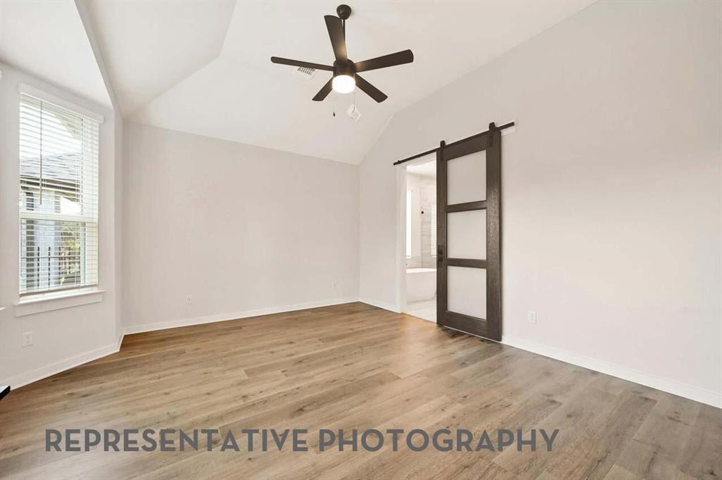 2620 Brooklyn Street Forney, TX 75126 - Photo 8 of 19 an empty room with wooden floor ceiling fan and windows