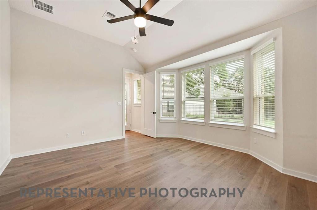 2620 Brooklyn Street Forney, TX 75126 - Photo 9 of 19 an empty room with wooden floor fan and windows