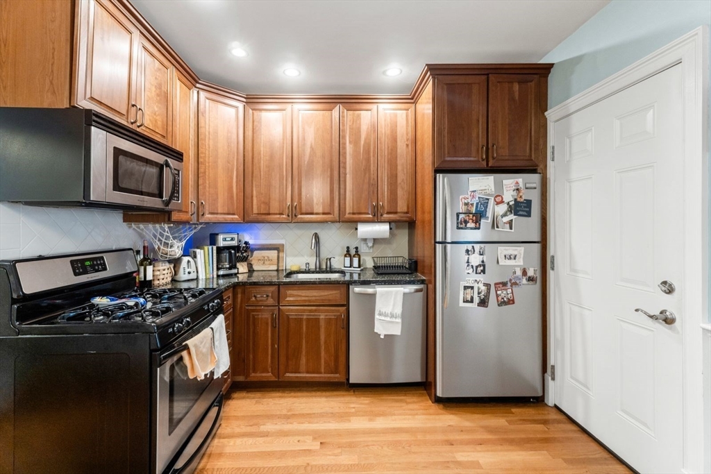 51-53 Story Street, Unit 1 Boston, MA 02127 - Photo 11 of 33 a kitchen with stainless steel appliances granite countertop a refrigerator stove and sink
