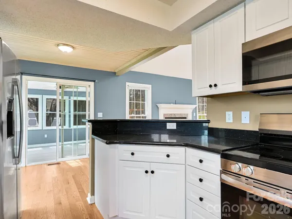 a kitchen with granite countertop a stove and a microwave