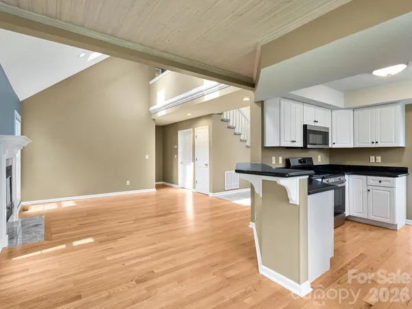 a view of kitchen with granite countertop cabinets and wooden floor